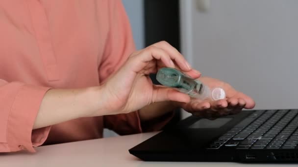 Weibchen verwenden Desinfektionsmittel, Desinfektionsmittel an den Händen, um sich vor Kolibakterien an der Laptop-Tastatur zu schützen. Nahaufnahme — Stockvideo