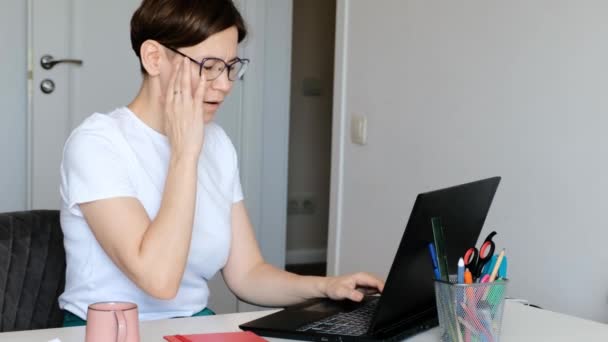 Müde, überarbeitete Dame hat Kopfschmerzen, Migräne mit dem Computer, der von zu Hause aus arbeitet. — Stockvideo