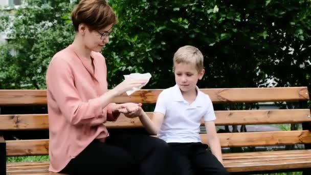 Frau reinigt Kinderhände mit feuchtem antiseptischem Wischtuch zum Schutz vor Coronavirus und Bakterien — Stockvideo