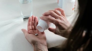 Hap alan ve bir bardak su içen kadın.