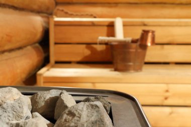 Buhar odasındaki ısıtıcı bakır sauna aksesuarlarının arka planında. Ortadaki taşa odaklan..