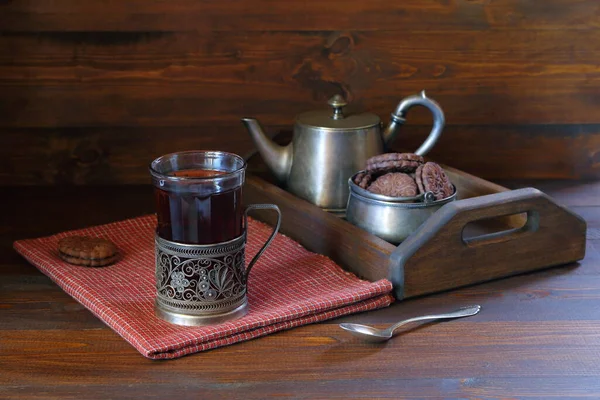 Koyu ahşap arka planda çikolatalı kurabiye ve retro tarzı çay partisi aletleri.. 
