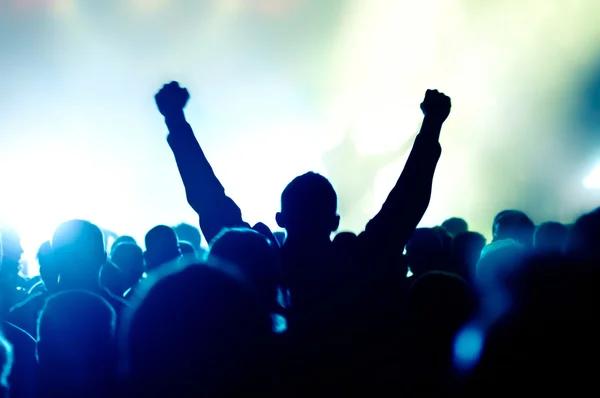 Siluetas de la multitud de conciertos frente a luces de escenario brillantes — Foto de Stock