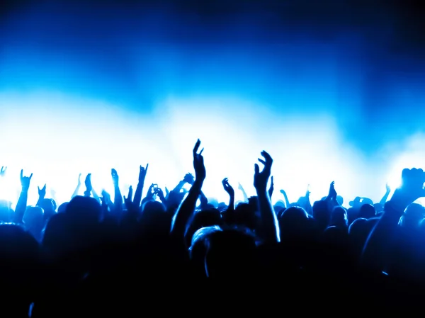 Silhouettes of concert crowd in front of bright stage lights — Stock Photo, Image