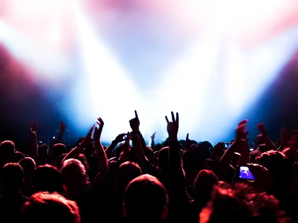 Siluetas de la multitud de conciertos frente a luces de escenario brillantes — Foto de Stock