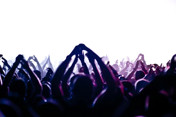 Parlak sahne ışıkları önünde konser kalabalığının siluetleri