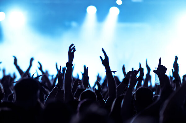silhouettes of concert crowd in front of bright stage lights