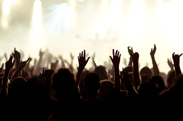 Siluetas de la multitud de conciertos frente a luces de escenario brillantes — Foto de Stock