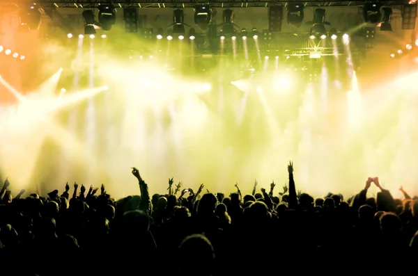 Silhuetas de multidão de concerto na frente de luzes de palco brilhantes — Fotografia de Stock