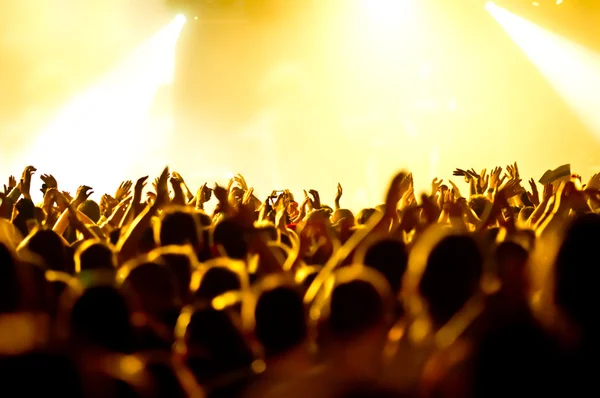 Siluetas de la multitud de conciertos frente a luces de escenario brillantes —  Fotos de Stock