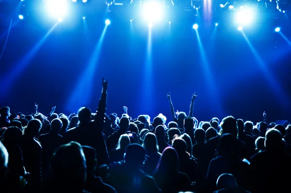 Siluetas de la multitud de conciertos frente a luces de escenario brillantes — Foto de Stock