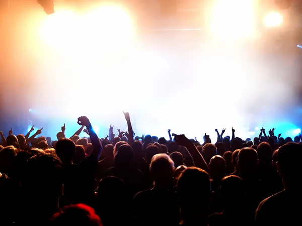 Siluetas de la multitud de conciertos frente a luces de escenario brillantes Fotos De Stock