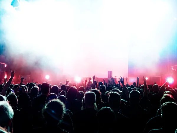 Siluetas de la multitud de conciertos frente a luces de escenario brillantes Imagen De Stock