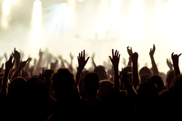 Silhouettes of concert crowd in front of bright stage lights Royalty Free Stock Images