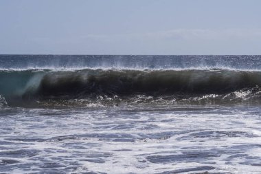 Büyük deniz dalgaları Tenerife 'nin volkanik kıyılarına doğru ilerliyor. Turkuaz su ve köpüklü güzel deniz manzarası Atlantik Okyanusu 'nun enerjisini gösteriyor..