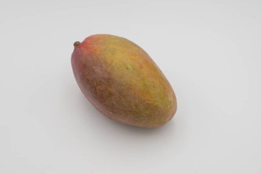 Beyaz arka planda pürüzsüz kırmızı ve sarı derili parlak olgun mango meyvesi.