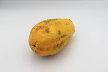 Beyaz arka planda izole edilmiş parlak olgun papaya meyvesi. Antioksidan, C vitamini ve lif açısından zengin egzotik tropikal meyveler. Doğal organik gıda ve vegan diyet konsepti.