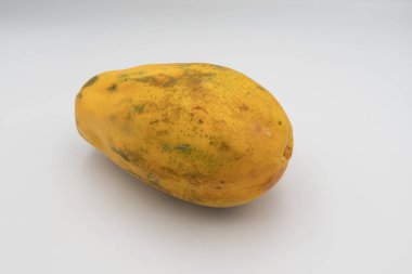 Beyaz arka planda izole edilmiş parlak olgun papaya meyvesi. Antioksidan, C vitamini ve lif açısından zengin egzotik tropikal meyveler. Doğal organik gıda ve vegan diyet konsepti.