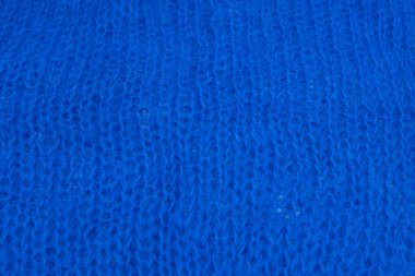 Yumuşak mavi yün kumaş dokusu ve detaylı lifler. Tasarım, moda ya da zanaat projeleri için samimi bir arka plan. Doğal dokuma ipliği desenli makro çekim.