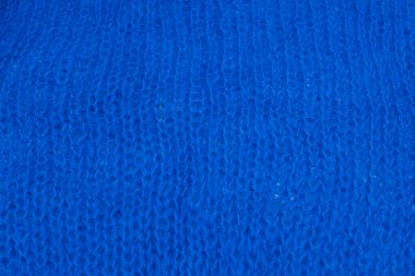 Yumuşak mavi yün kumaş dokusu ve detaylı lifler. Tasarım, moda ya da zanaat projeleri için samimi bir arka plan. Doğal dokuma ipliği desenli makro çekim.