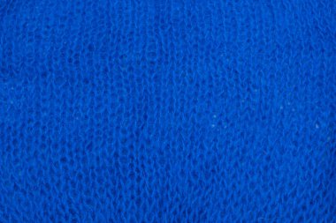 Yumuşak mavi yün kumaş dokusu ve detaylı lifler. Tasarım, moda ya da zanaat projeleri için samimi bir arka plan. Doğal dokuma ipliği desenli makro çekim.