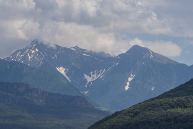 Dağ manzarası, orman tepeleri ve karla kaplı bayır.