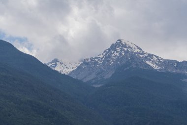 Dağ manzarası, orman tepeleri ve karla kaplı bayır.