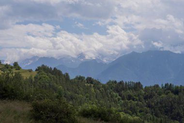 Dağ manzarası, orman tepeleri ve karla kaplı bayır.