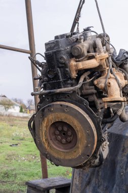 Eski arabanın motoru, açık hava tamir alanındaki bir asansörde kaldırıldı. Otomobil bakım, mühendislik ve restorasyonu temsil eden endüstriyel mekanik sahnesi.