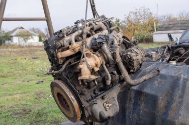 Eski arabanın motoru, açık hava tamir alanındaki bir asansörde kaldırıldı. Otomobil bakım, mühendislik ve restorasyonu temsil eden endüstriyel mekanik sahnesi.