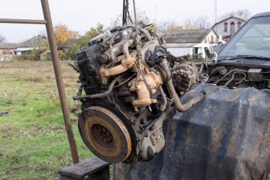 Eski arabanın motoru, açık hava tamir alanındaki bir asansörde kaldırıldı. Otomobil bakım, mühendislik ve restorasyonu temsil eden endüstriyel mekanik sahnesi.
