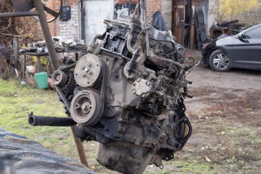 Eski arabanın motoru, açık hava tamir alanındaki bir asansörde kaldırıldı. Otomobil bakım, mühendislik ve restorasyonu temsil eden endüstriyel mekanik sahnesi.