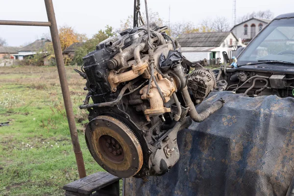 Eski arabanın motoru, açık hava tamir alanındaki bir asansörde kaldırıldı. Otomobil bakım, mühendislik ve restorasyonu temsil eden endüstriyel mekanik sahnesi.