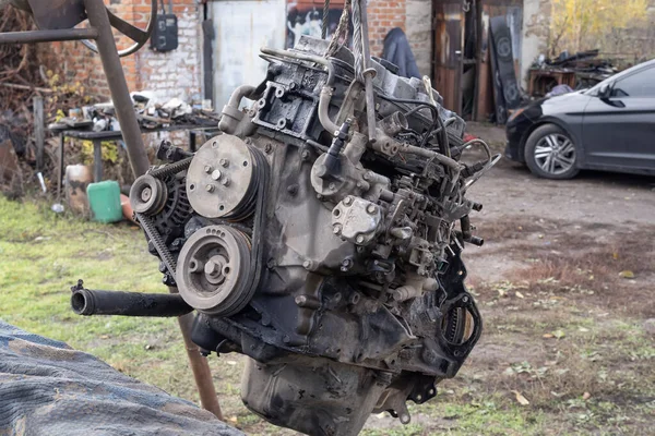 Eski arabanın motoru, açık hava tamir alanındaki bir asansörde kaldırıldı. Otomobil bakım, mühendislik ve restorasyonu temsil eden endüstriyel mekanik sahnesi.