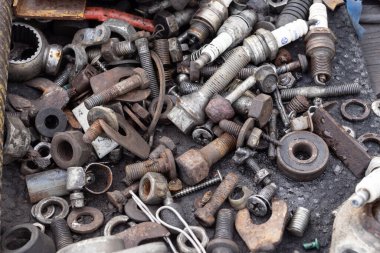 Paslı metal parçaları, cıvatalar ve elektrik kablolarının karışımı. Geri dönüşümü, aşınmayı, endüstriyel atıkları ve çevresel metal kullanımını sembolize eden ayrıntılı makro doku.