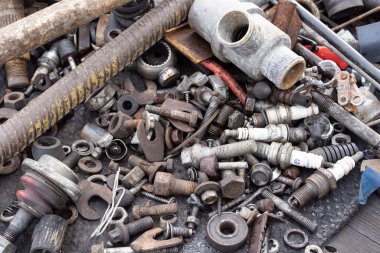 Paslı metal parçaları, cıvatalar ve elektrik kablolarının karışımı. Geri dönüşümü, aşınmayı, endüstriyel atıkları ve çevresel metal kullanımını sembolize eden ayrıntılı makro doku.