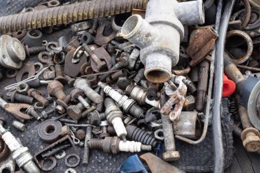 Paslı metal parçaları, cıvatalar ve elektrik kablolarının karışımı. Geri dönüşümü, aşınmayı, endüstriyel atıkları ve çevresel metal kullanımını sembolize eden ayrıntılı makro doku.