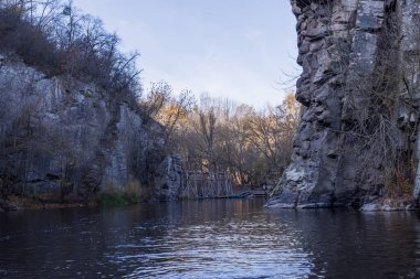 Kayalık uçurumlar, sakin bir nehir, sonbahar bitki örtüsü ve sıcak doğal tonların yer aldığı Busky Canyon manzarası. Sakin ve vahşi bir manzara, yumuşak gün ışığında yakalanır..