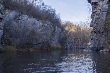 Kayalık uçurumlar, sakin bir nehir, sonbahar bitki örtüsü ve sıcak doğal tonların yer aldığı Busky Canyon manzarası. Sakin ve vahşi bir manzara, yumuşak gün ışığında yakalanır..