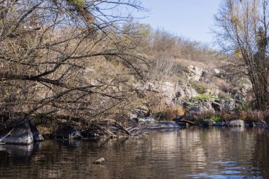 Kayalık uçurumlar, sakin bir nehir, sonbahar bitki örtüsü ve sıcak doğal tonların yer aldığı Busky Canyon manzarası. Sakin ve vahşi bir manzara, yumuşak gün ışığında yakalanır..