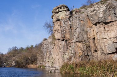 Katmanlı kaya kayalıkları ve engebeli bir kanyon yüzeyinde aşınma, katman ve ham jeolojik dokuları gösteren doğal kaya oluşumları..