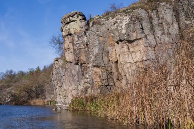 Katmanlı kaya kayalıkları ve engebeli bir kanyon yüzeyinde aşınma, katman ve ham jeolojik dokuları gösteren doğal kaya oluşumları..