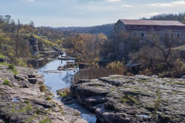 Katmanlı kaya kayalıkları ve engebeli bir kanyon yüzeyinde aşınma, katman ve ham jeolojik dokuları gösteren doğal kaya oluşumları..
