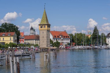 Lindau eski kasaba limanı Mangturm kulesi, gezinti güvertesi, tekneler ve güneşli bir günde sakin Constance Gölü suyu
