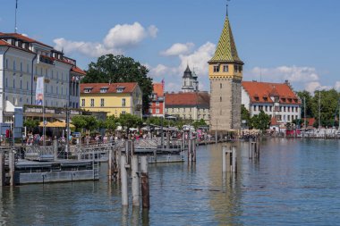 Lindau eski kasaba limanı Mangturm kulesi, gezinti güvertesi, tekneler ve güneşli bir günde sakin Constance Gölü suyu