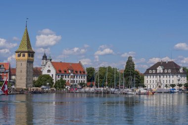 Lindau eski kasaba limanı Mangturm kulesi, gezinti güvertesi, tekneler ve güneşli bir günde sakin Constance Gölü suyu