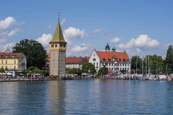 Lindau eski kasaba limanı Mangturm kulesi, gezinti güvertesi, tekneler ve güneşli bir günde sakin Constance Gölü suyu