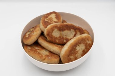 Bir kaseye istiflenmiş kızarmış hamur tatlısı yakın çekim. Beyaz arka planda doğal dokuyla izole edilmiş ev yapımı geleneksel yemekler..