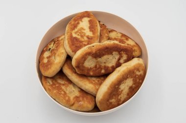 Bir kaseye istiflenmiş kızarmış hamur tatlısı yakın çekim. Beyaz arka planda doğal dokuyla izole edilmiş ev yapımı geleneksel yemekler..