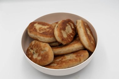 Bir kaseye istiflenmiş kızarmış hamur tatlısı yakın çekim. Beyaz arka planda doğal dokuyla izole edilmiş ev yapımı geleneksel yemekler..